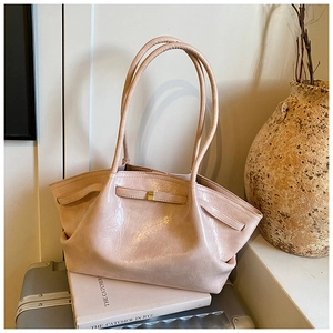 Detail of light pink pleated tote bag with golden buckle and sleek long handle