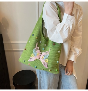 Détail du sac fourre-tout en tricot vert avec broderie papillon 3D et perles décoratives