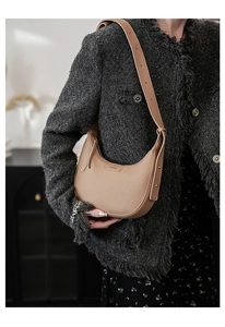 Nahaufnahme der beigen Lychee-Lederstruktur und Metallnieten-Details der Hobo-Tasche