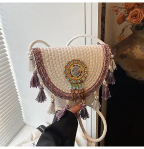 Detail of bohemian woven crossbody bag featuring colorful bead charms and purple fringe trim