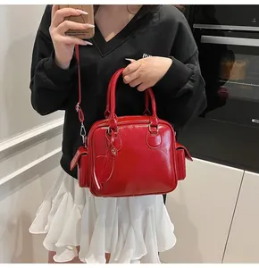 Detailed shot of red patent leather bowling bag with heart charm and detachable strap
