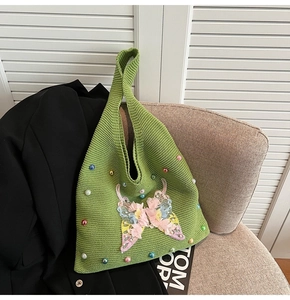 Détail d'un sac cabas en tricot vert avec broderie papillon 3D et perles colorées