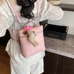 Pink lychee texture backpack with cute plush puppy charm worn by a model