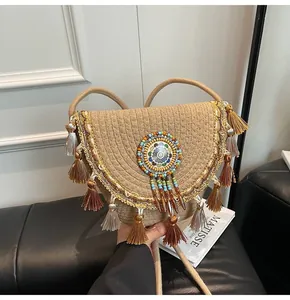 Detail of bohemian straw bag with fringe tassels and colorful ethnic embroidery