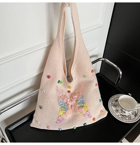 Detail of light pink knit tote bag with 3D floral butterfly and colorful beads