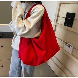 Detail van de rode canvas tote bag met brede schouderriem en ruime opbergcapaciteit