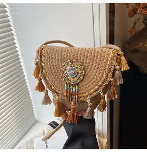 Detail of bohemian straw shoulder bag with colorful beads and long tassel accents