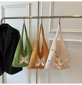 Detailed view of handmade knitted tote bags featuring 3D butterfly appliqués and pearls