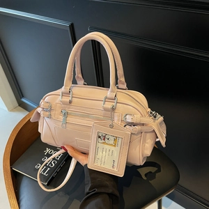 Elegant light pink leather handbag with silver hardware and a cute bear card charm