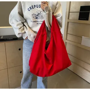 Macro-opname van een grote rode canvas hobo-tas met trekkoorddetail en zachte textuur
