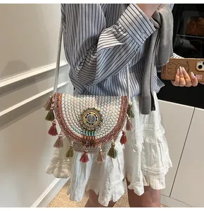 Close-up of bohemian woven crossbody bag with colorful tassel fringe and bead embroidery