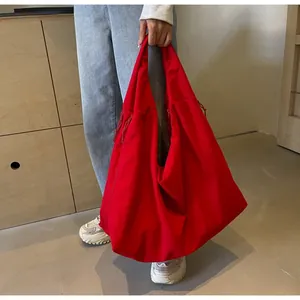 Detail van rode canvas draagtas met trekkoord aan de zijkant en ruim interieur