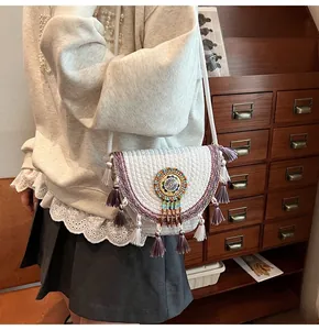 Detail of bohemian straw bag with beaded mandala pattern and vibrant tassels decor