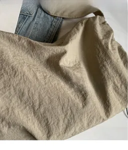 Close-up of the beige nylon fabric with soft crinkle texture on the large shoulder bag