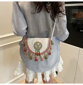 Detail of bohemian straw bag with colorful beads embroidery and vibrant tassel trim