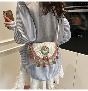 Detail of bohemian woven crossbody bag featuring colorful tassels and beadwork