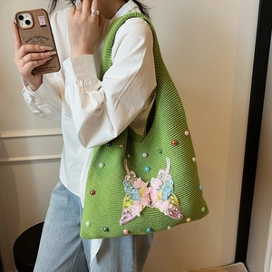 Sac fourre-tout en tricot vert avec applique papillon rose et perles sur mannequin