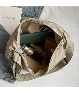 Internal view of the large capacity nylon crossbody bag holding a tablet and cosmetics