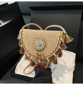 Close-up of bohemian straw bag with colorful tassels and ethnic beadwork in gift box