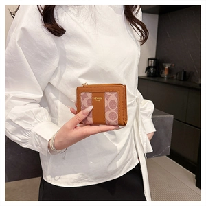Dettaglio mini portafoglio marrone con monogramma da donna e cerniera dorata elegante