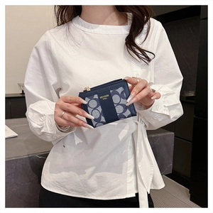 Dettaglio della piccola pochette blu monogramma con cerniera dorata e logo