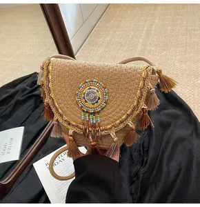 Detailed close-up of straw woven bag featuring colorful tassels and ethnic beaded patterns
