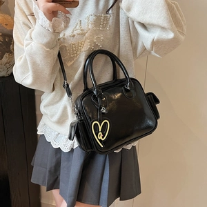 Glossy black patent leather tote bag with heart charm and crossbody strap for women