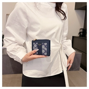 Dettaglio di piccola pochette quadrata con contrasto in pelle blu e motivo monogramma