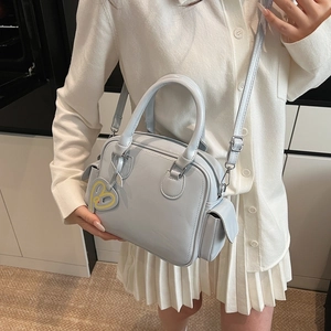 Light blue faux leather Boston tote bag with shoulder strap and heart charm accessory