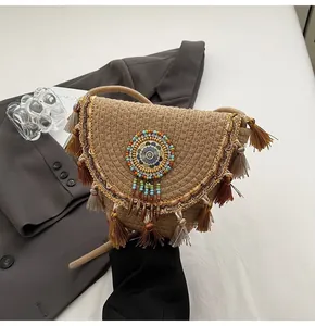 Detailed close-up of straw woven bag featuring bead embroidery and fringe accents