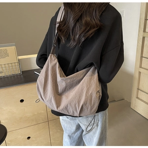 Detailed view of the large capacity crossbody bag showing nylon material and texture
