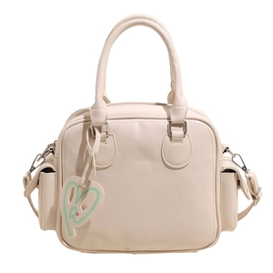 Cream white bowling tote bag with double handles and heart charm on white background