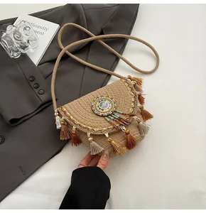Detail of bohemian straw crossbody bag featuring colorful bead embroidery and tiered tassels