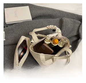 Innenraum-Detail der beigen Beuteltasche mit Litschi-Muster und passender kleiner Tasche