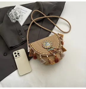Detailed close-up of handmade straw bag featuring ethnic beadwork and multi-tone tassels