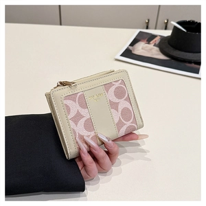 Dettaglio del piccolo portamonete in pelle beige e tessuto jacquard con monogramma rosa