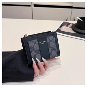 Dettaglio pochette quadrata nera e grigia con cerniera dorata e stampa logo elegante