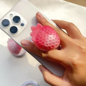 Pink frosted strawberry shape collapsible phone grip stand mounted on a smartphone