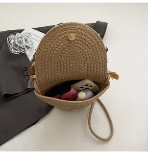 Detail view of woven straw shoulder bag with fringe trim and magnetic closure inside