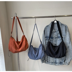 Detailed view of adjustable wide straps and nylon fabric on large crossbody bags