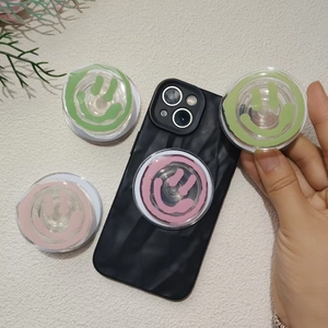 Transparent acrylic smile face phone socket grip in pink, mint, and green colors