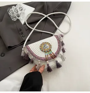 Close-up of white woven bag with colorful ethnic beads and purple tassels detail