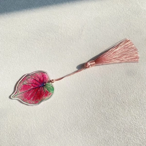 Detailed shot of an acrylic leaf bookmark with pink silk tassel and fine leaf patterns