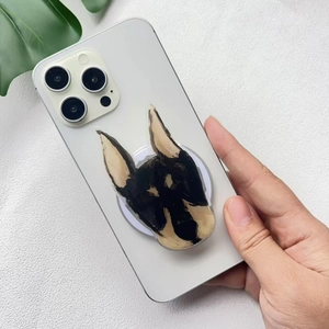 Detail of cute Doberman dog acrylic phone socket grip mounted on a white smartphone