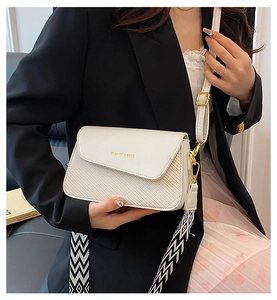 Detail view of stylish square bag with leather-woven texture and dual shoulder straps