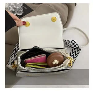 Interior view of white crossbody bag showing large storage for phone and sunglasses