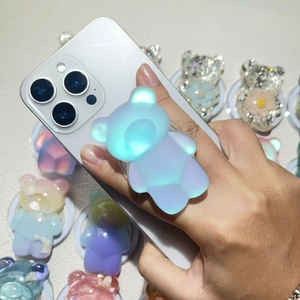 Polarized blue bear expandable phone grip stand held on a silver smartphone