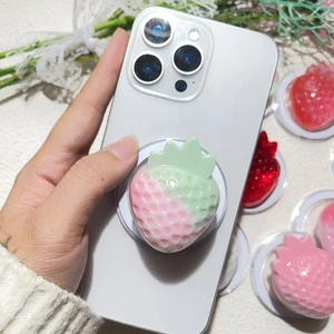 Detail of 3D pink strawberry MagSafe phone grip with realistic textured resin finish