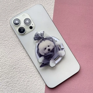 Close-up of cute white puppy design phone grip stand on a white smartphone back