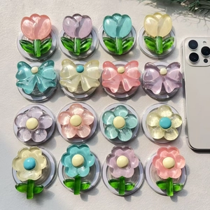 Dettaglio di 16 supporti per telefono in resina traslucida colorata a forma di fiori